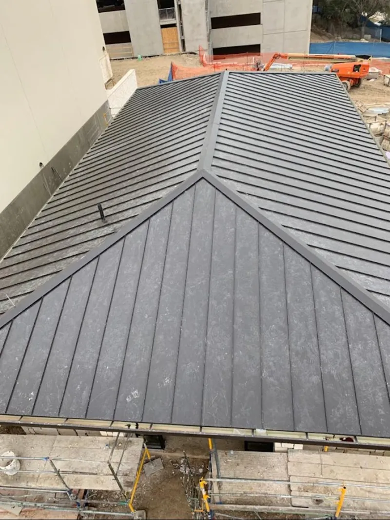 Commercial metal roof construction with crane equipment in North Providence